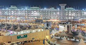 Mina'da gece vakti, aydınlatılmış çok katlı binalar ve hacıların konakladığı çadırların oluşturduğu kalabalık bir şehir manzarası.